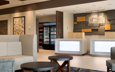 A lobby with seating, a reception desk, and a refrigerator stocked with beverages.