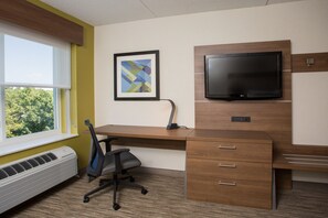 Een moderne kantoorruimte met een bureau, stoel, airconditioning en een wandgemonteerde flatscreen-tv.
