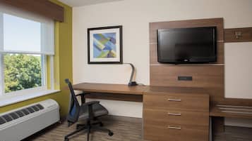 Un espace de bureau moderne comprenant un bureau, une chaise, un climatiseur et un téléviseur fixé au mur.