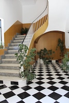 Una escalera con piso a cuadros y plantas en macetas.