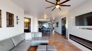 Una sala de estar moderna con un sofá modular, una chimenea y un televisor montado en la pared.