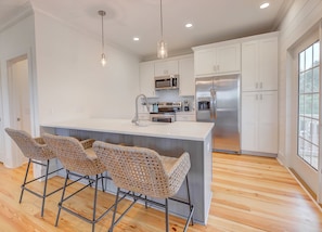 Enjoy cooking in this well-equipped kitchen with a central island, oven, and stainless steel sink.