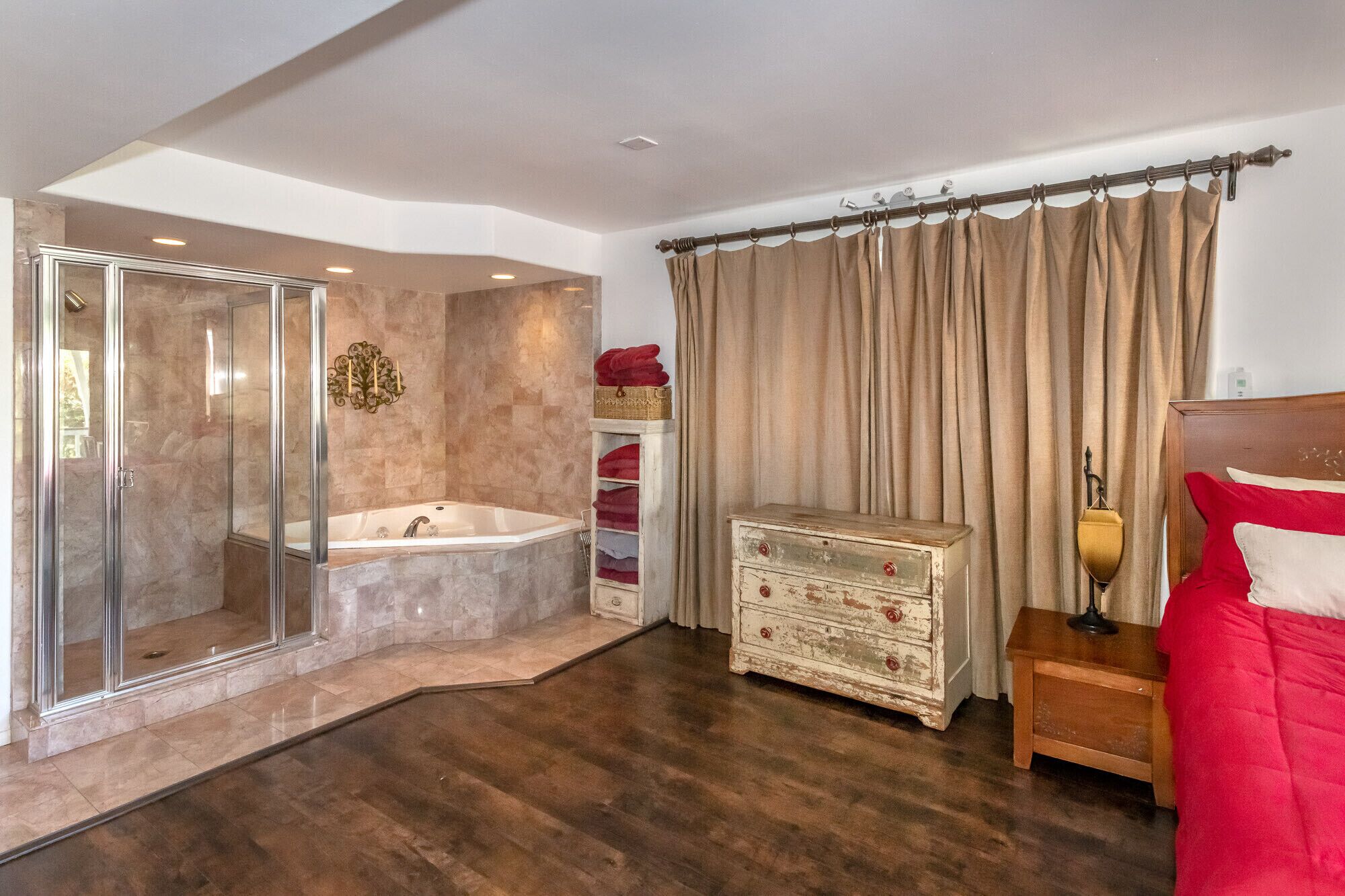 Un bagno con cabina doccia in vetro, una vasca da bagno e un mobile lavabo con specchio e portasciugamani.