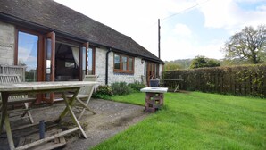 A stone building with a wooden table and chairs outside. - The Dairy , Petersfield -  a barn conversion that sleeps 4 guests  in 1 bedroom (Petersfield)