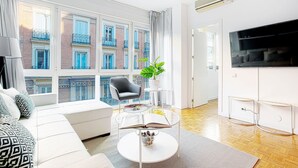 Una sala de estar moderna con un sofá, una mesa de centro y un televisor.