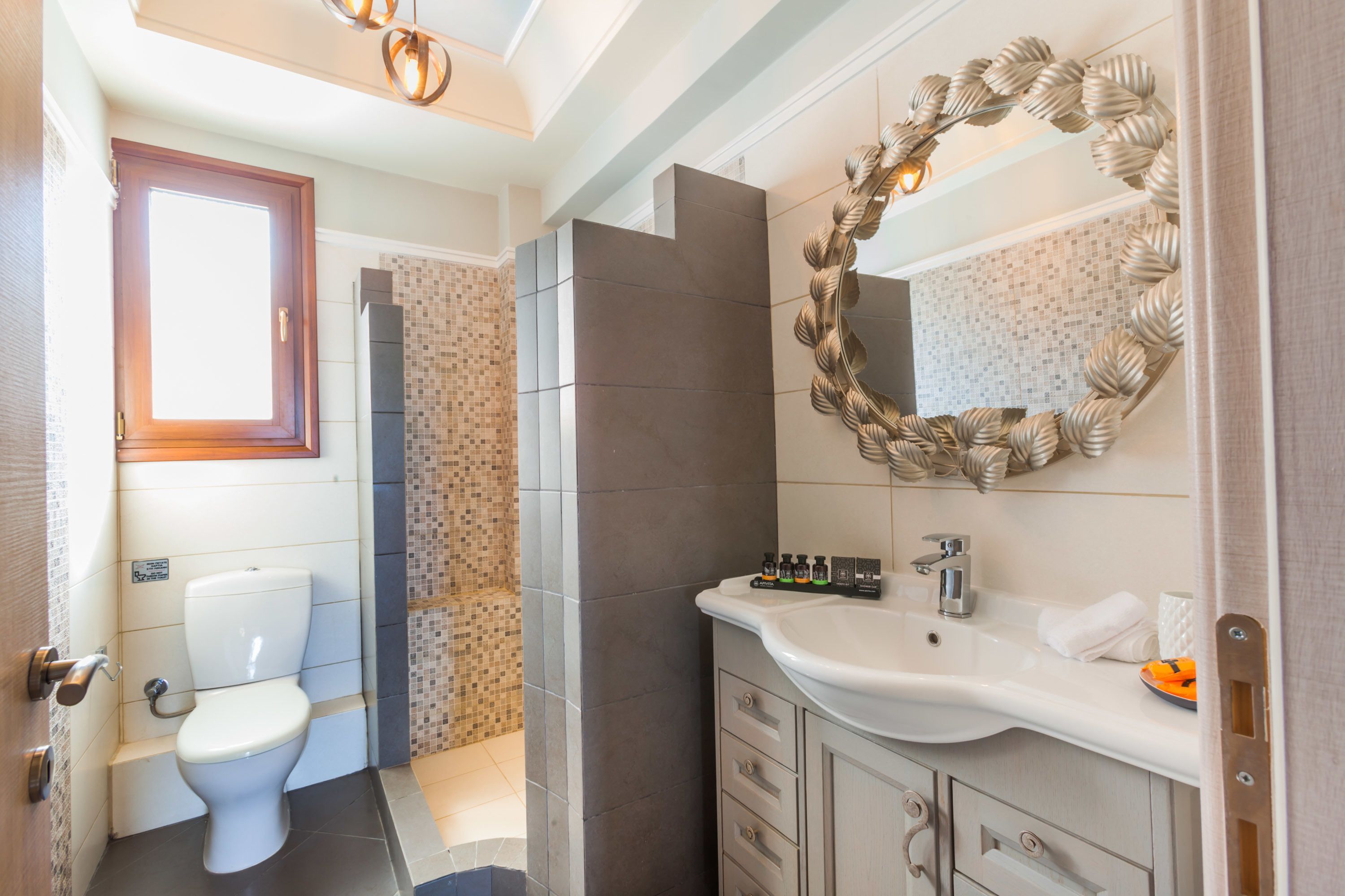 A bathroom with a toilet, sink, and mirror.