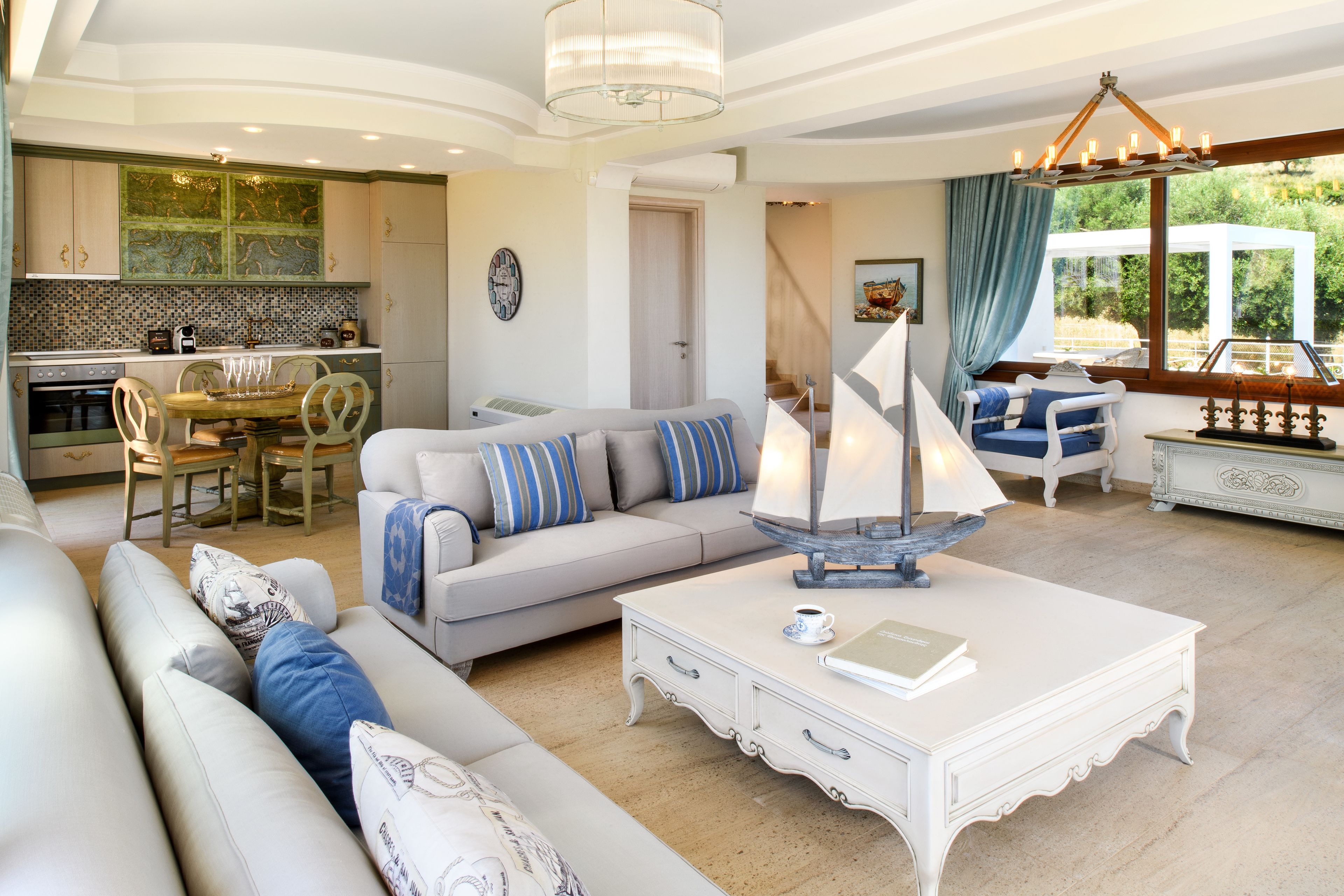 A spacious living area with a sofa, coffee table, and a view of the kitchen and outdoor deck.