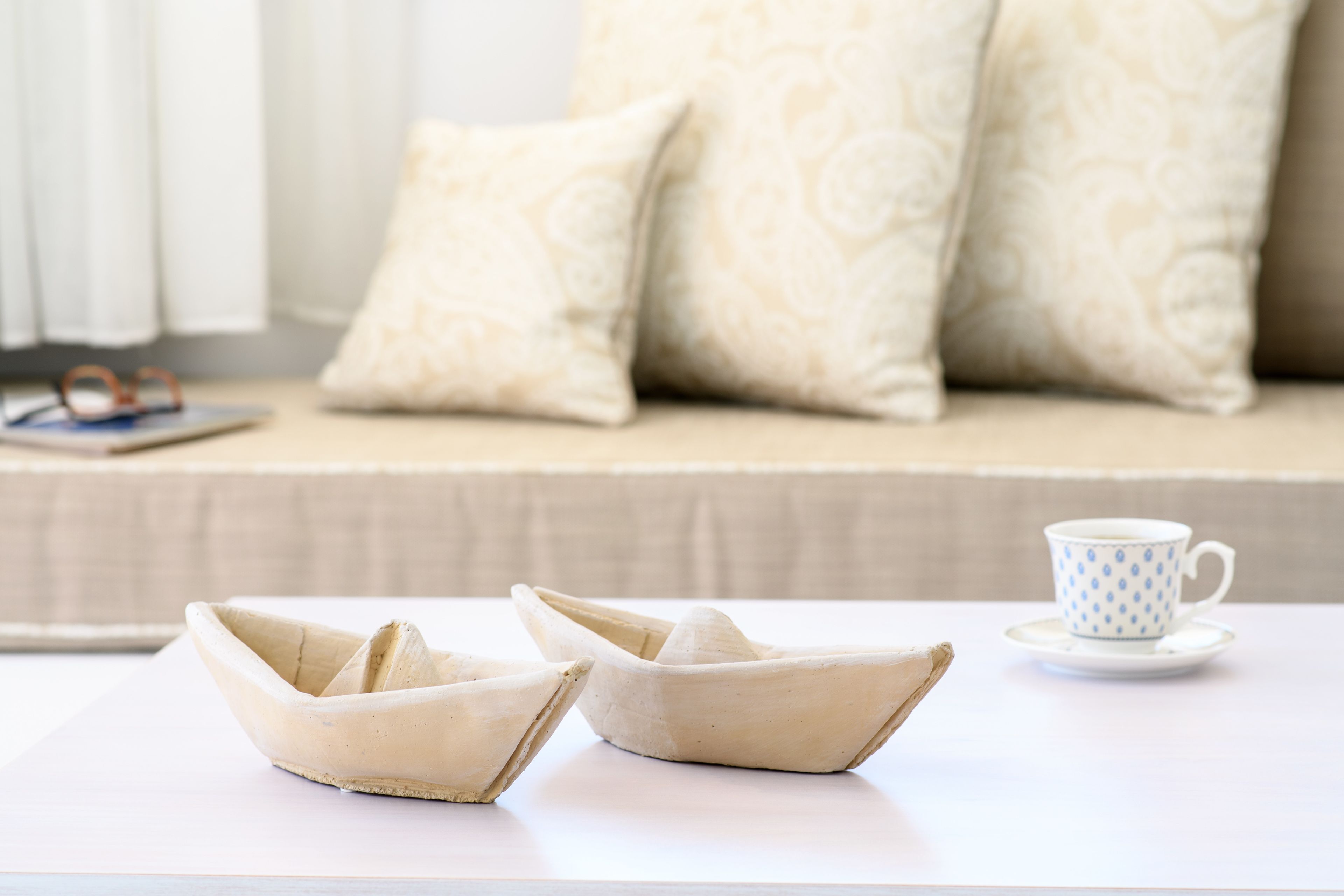 A table with two ceramic boats, a cup, and saucer.