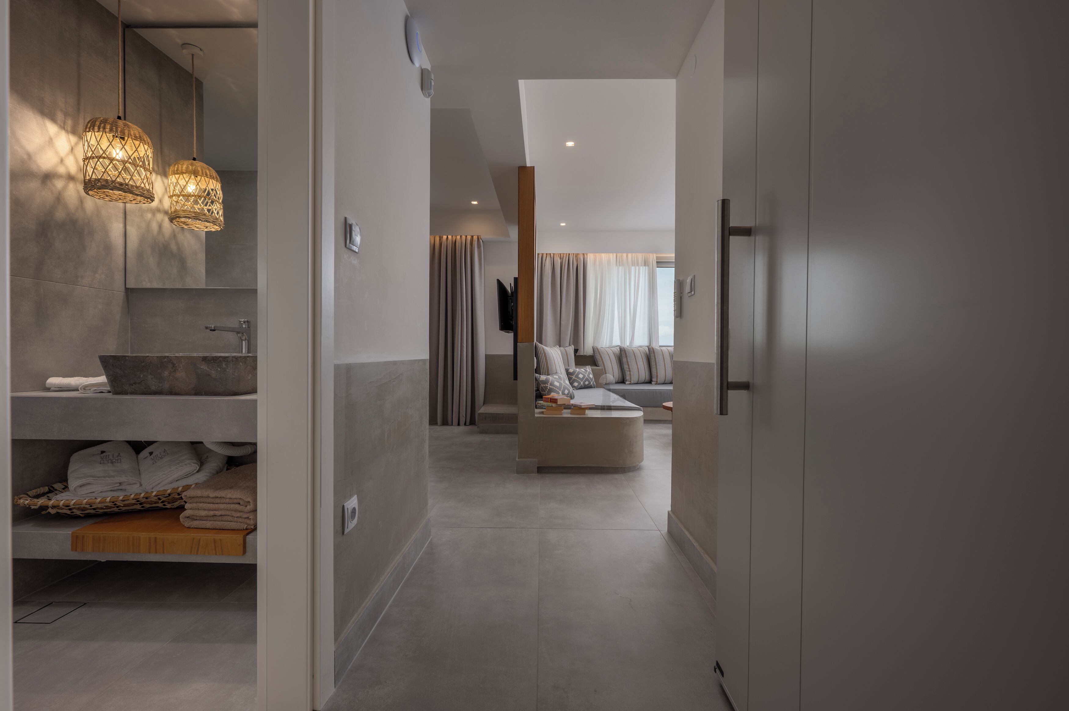 A modern bathroom with a large sink, towel rack, and a shower area.