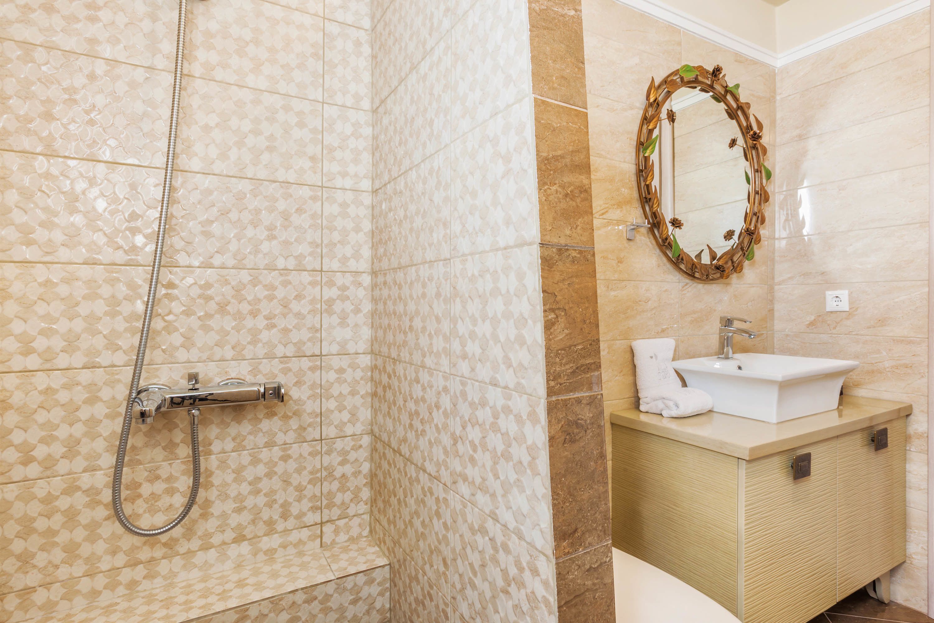 A bathroom with a shower, a sink, and a mirror.