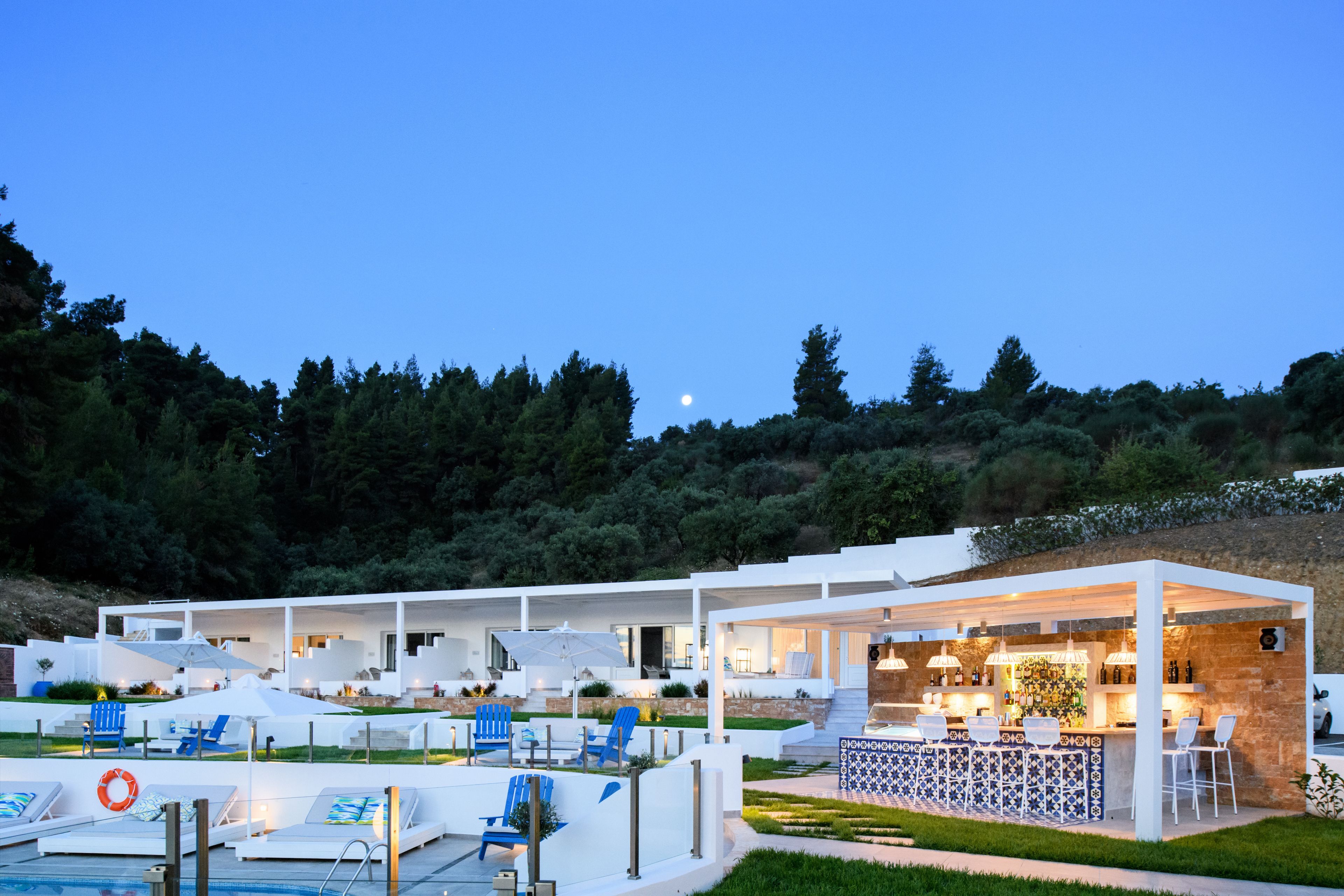 Ein moderner Poolbereich im Freien mit Liegestühlen, einer Bar und einer Poolbar.