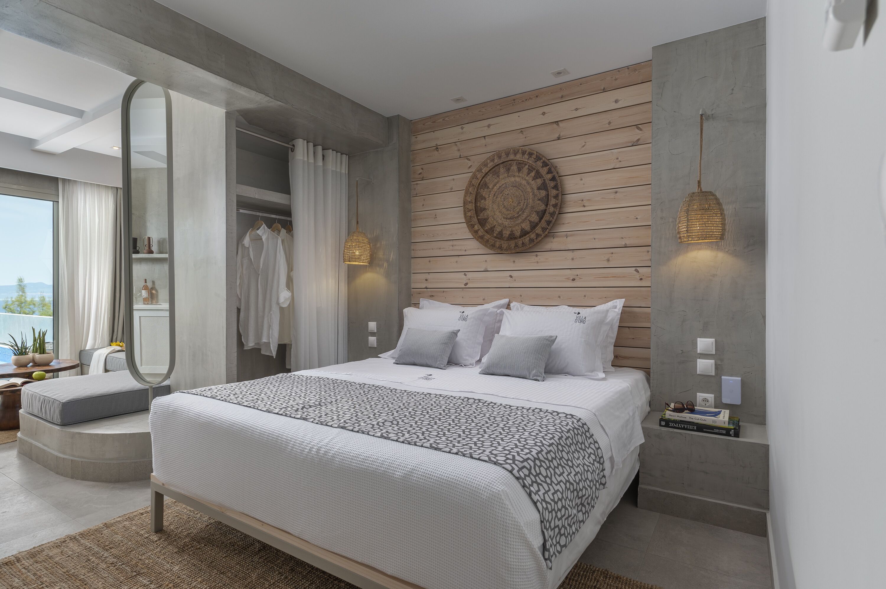 Un dormitorio moderno con una cama grande, un vestidor y vistas al exterior.