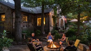 A stone house with a fire pit in the center, surrounded by outdoor seating. - Chanticleer Inn (Lookout Mountain)