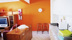 A compact kitchen with a microwave, gas stove, and stools. - Algarve Panorama Holidays (Portimão)