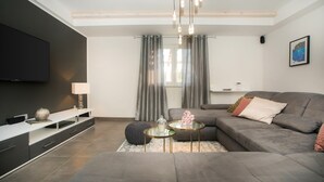 A modern living room with a grey sofa, a coffee table, and a TV on a stand. - Villa Red Hacienda with Pool (Vodice)