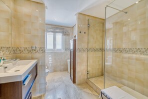 Une salle de bain moderne avec une douche à parois de verre, un meuble-lavabo et des toilettes.