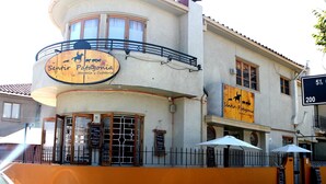 Un edificio con un letrero que dice "Sentir Patagonia Hostería y Cafetería" y un balcón con barandilla.