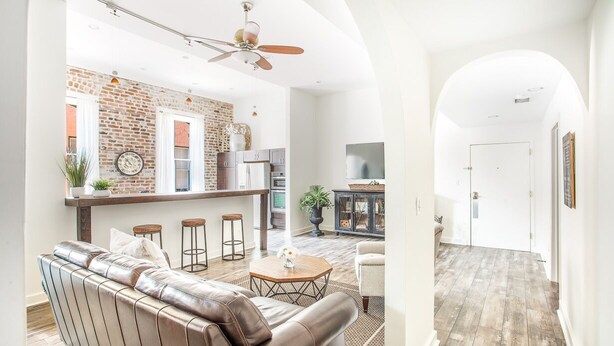 Een moderne woonkamer met een leren bank, een salontafel en een bakstenen muur.