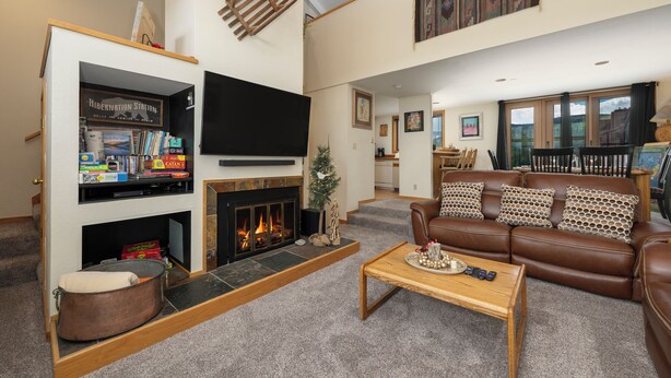 Ein Wohnzimmer mit Kamin, Fernseher, Sofa und Couchtisch.
