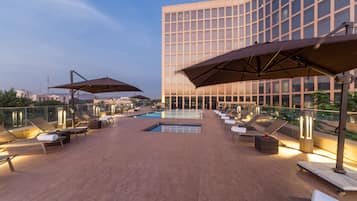 Una piscina al aire libre, sillones reclinables de piscina