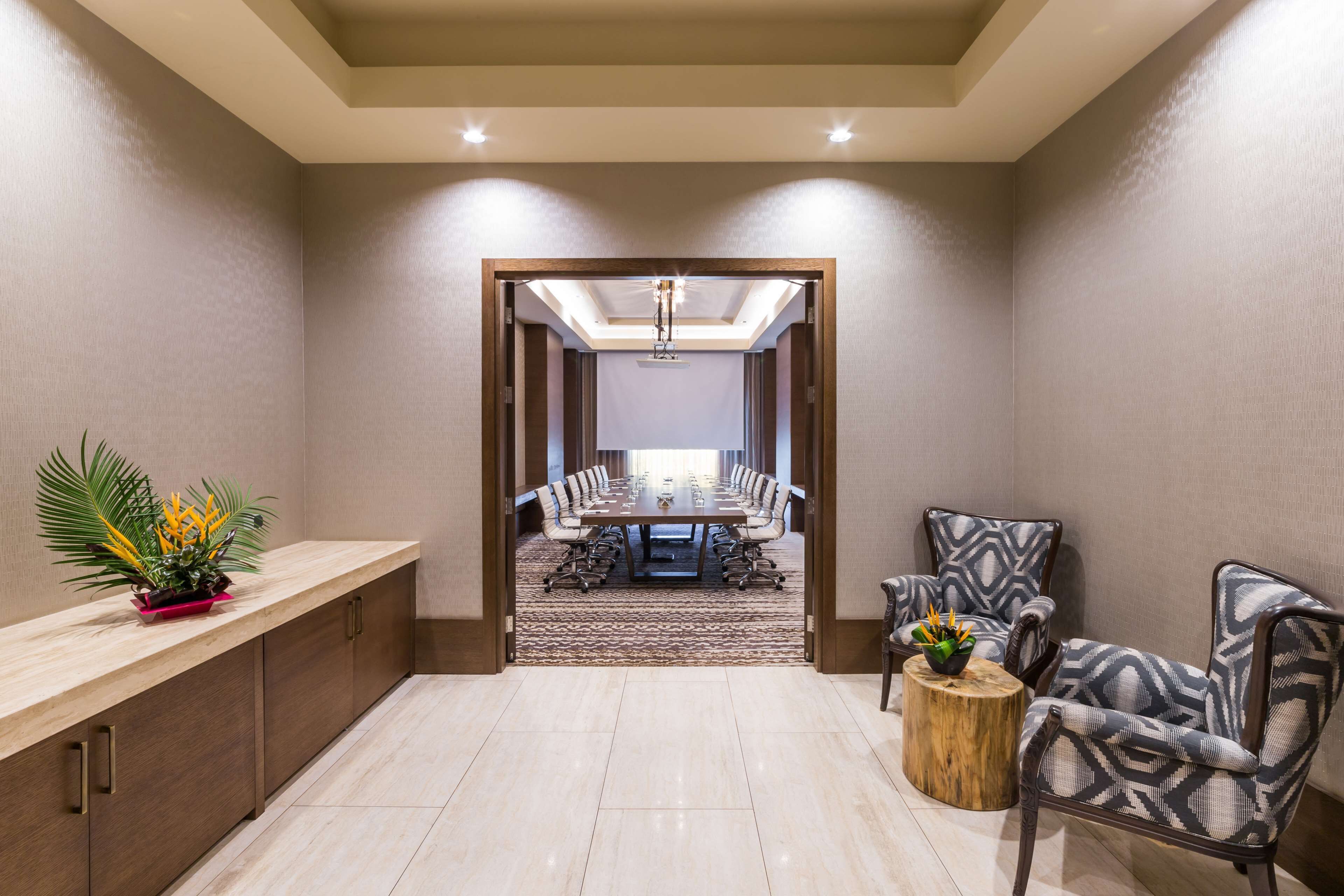 A conference room with a long table, chairs, and a wooden sideboard.