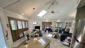 A spacious living area with a kitchen, dining table, and seating.