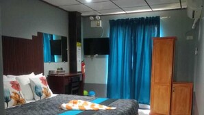 A bedroom with a bed, a desk, a wardrobe, and a television. - Hwan Dynasty Suite Elnido (El Nido)