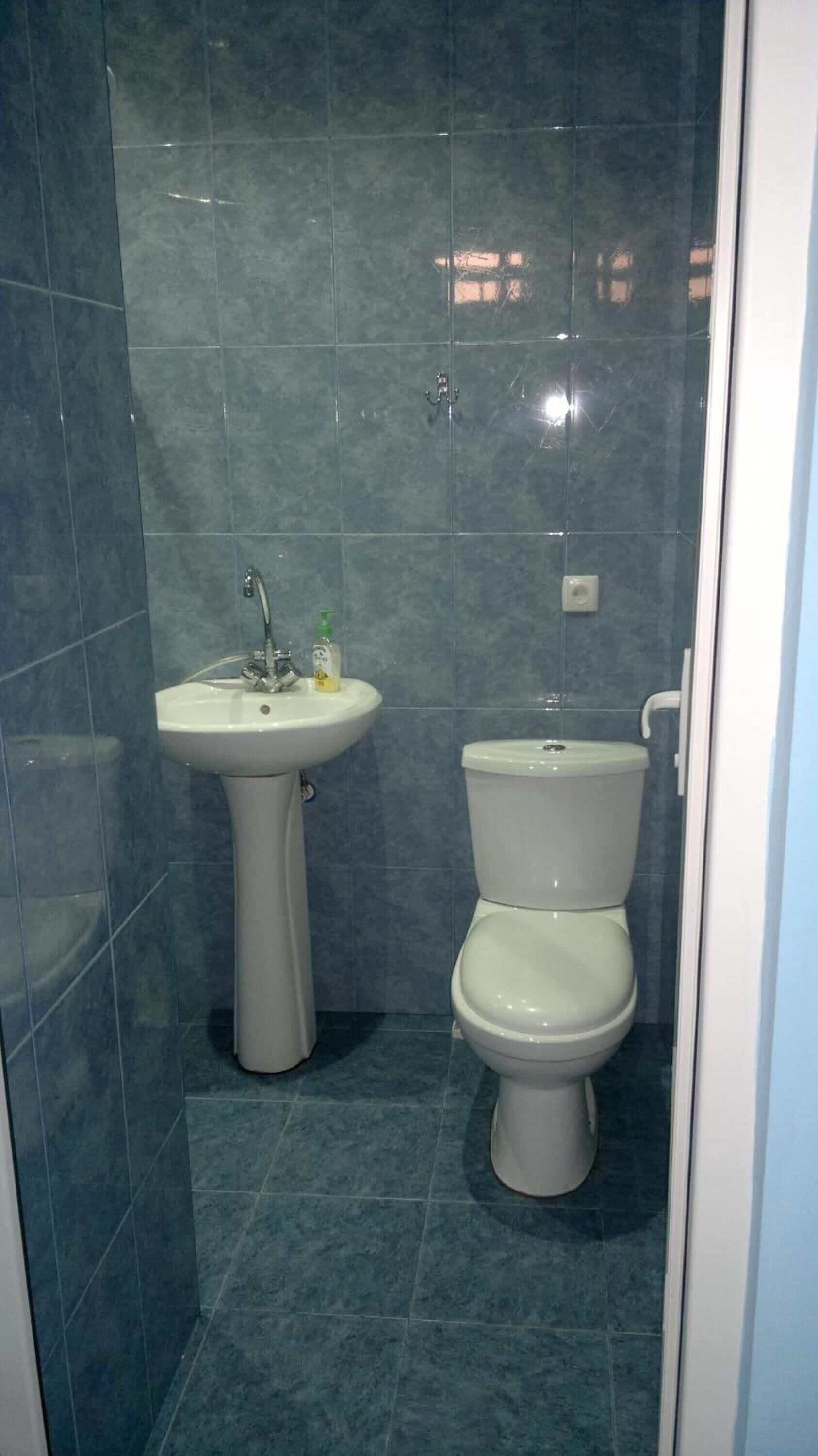 A bathroom with a pedestal sink and a toilet.