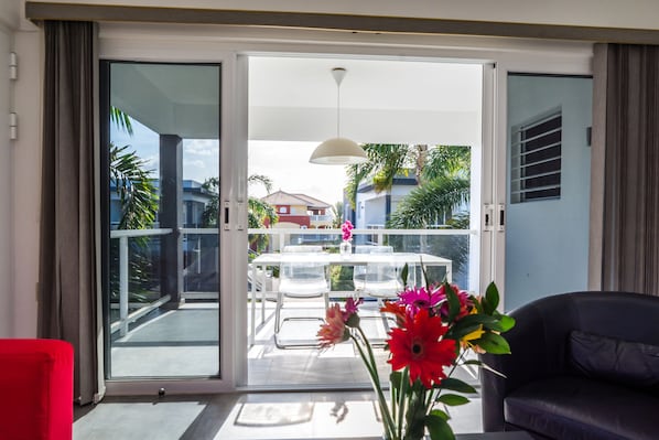 A modern living room with a sliding glass door leading to a balcony.