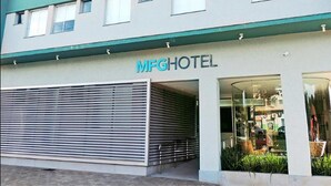 Un hotel con techo plano, un letrero que dice "MFG HOTEL" y una puerta de garaje cerrada.