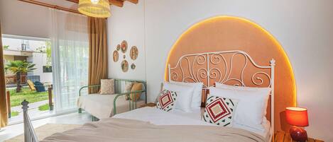 Une chambre à coucher avec un lit, une lampe de chevet, une vue sur l’extérieur et un plafond avec des poutres en bois.