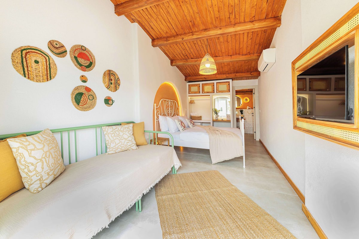 A cozy room with two beds, a wooden ceiling, and woven wall art.
