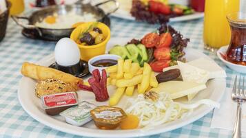 A plate of food with various items including eggs, fries, and vegetables.