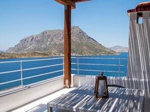Ein Balkon mit Blick auf das Meer und ein Berg.