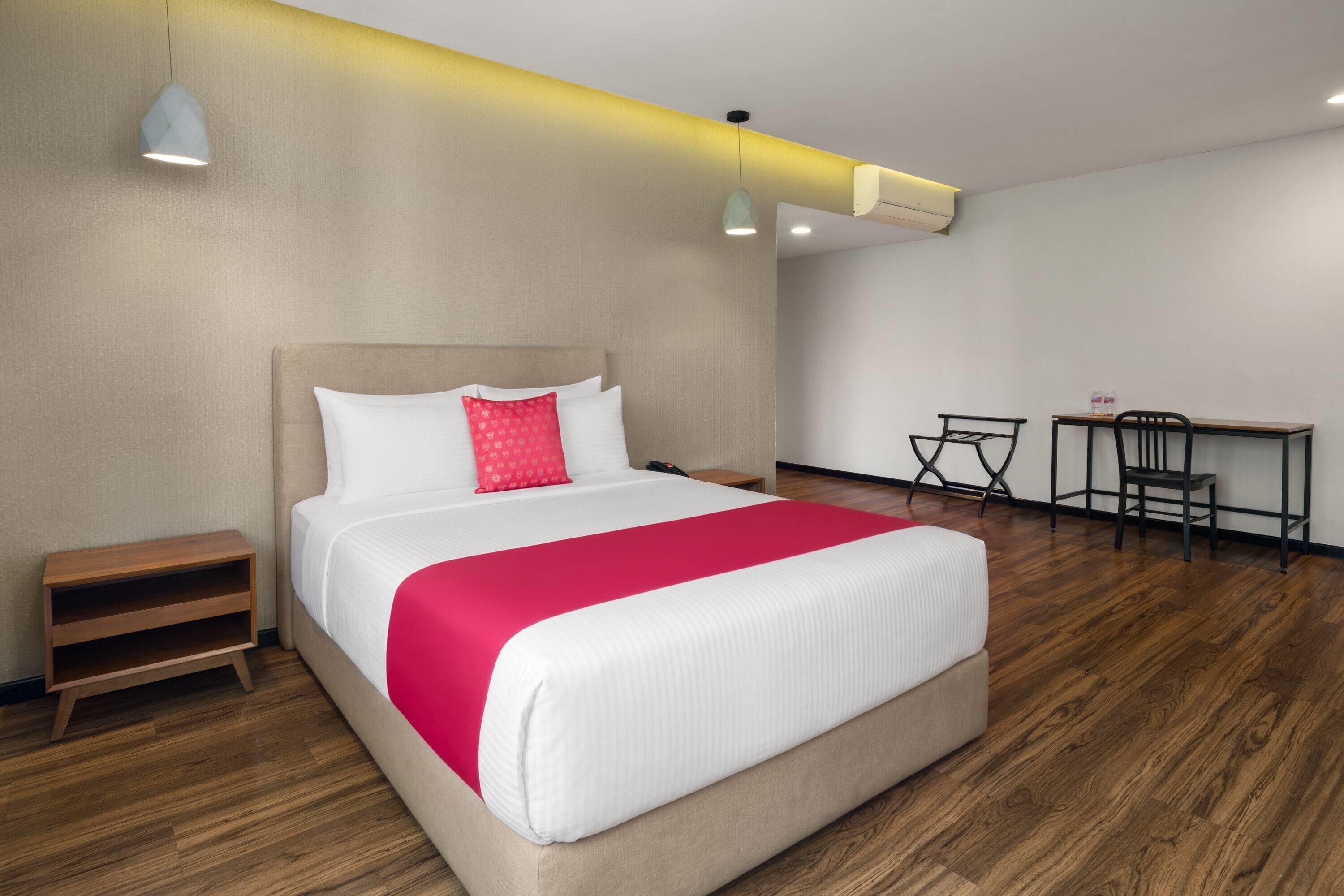 Une chambre d’hôtel comprenant un lit, des tables de chevet, un bureau et des chaises.