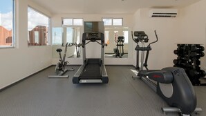 Ein modernes Fitnessstudio mit Laufband, Ergometer und Rudergerät.