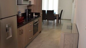Eine moderne Küche mit Edelstahlgeräten, Holzschränken und einem Essbereich mit Tisch und Stühlen.