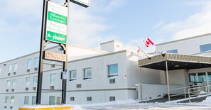 A building with multiple signs indicating various amenities such as a pool, lounge, dining room, and a specific room named 'the Whinder'.