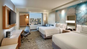 A hotel room with two beds, a desk, a chair, a TV, and a large window offering a city view. - Courtyard by Marriott Los Angeles LAX/Hawthorne (Hawthorne)