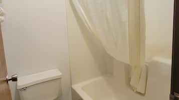 A bathroom with a toilet, bathtub, and shower curtain.