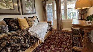 A bedroom with a bed, a desk, a lamp, and a window with curtains. - Timeless Elegance ~ 1920's Sam Hughes Casita Mariposa ~ Walk to UA! Parking (Tucson)