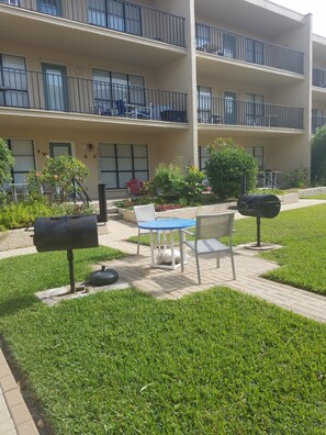 Ein mehrstöckiges Gebäude mit Balkonen, Außenplätzen und einem gepflegten Garten.