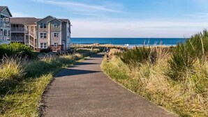 Un chemin menant à un bâtiment d’où l’on a une vue sur la mer.