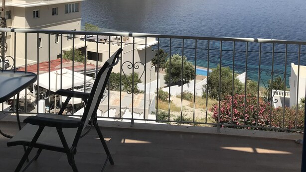 Un balcó amb vista a una muntanya i al mar.