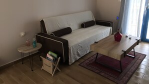 Un saló amb un sofà, una taula de centre, una taula auxiliar i un arxivador de revistes.