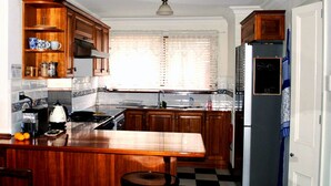 Una cucina con mobili in legno, un forno, un lavello e un frigorifero.