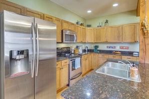 A modern kitchen with stainless steel appliances, wooden cabinets, granite countertops, and a built-in sink. - 'Bozeman Getaway' w/ Mountain Views, Near Downtown (Bozeman)