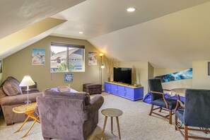 A living room with a sofa, a chair, a television on a blue cabinet, and a lamp. - 'Bozeman Getaway' w/ Mountain Views, Near Downtown (Bozeman)