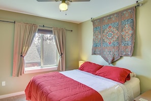 A bedroom with a bed, curtains, a window, a wall tapestry, and a ceiling fan. - 'Bozeman Getaway' w/ Mountain Views, Near Downtown (Bozeman)