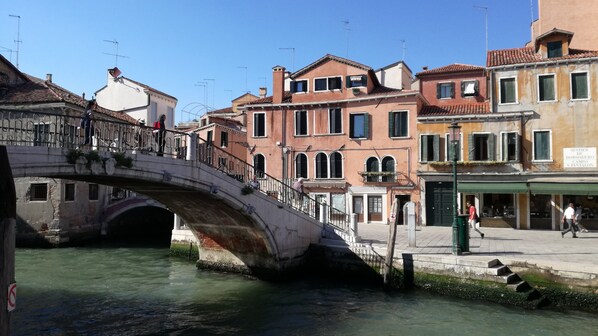 Un puente de piedra sobre un canal flanqueado por edificios.